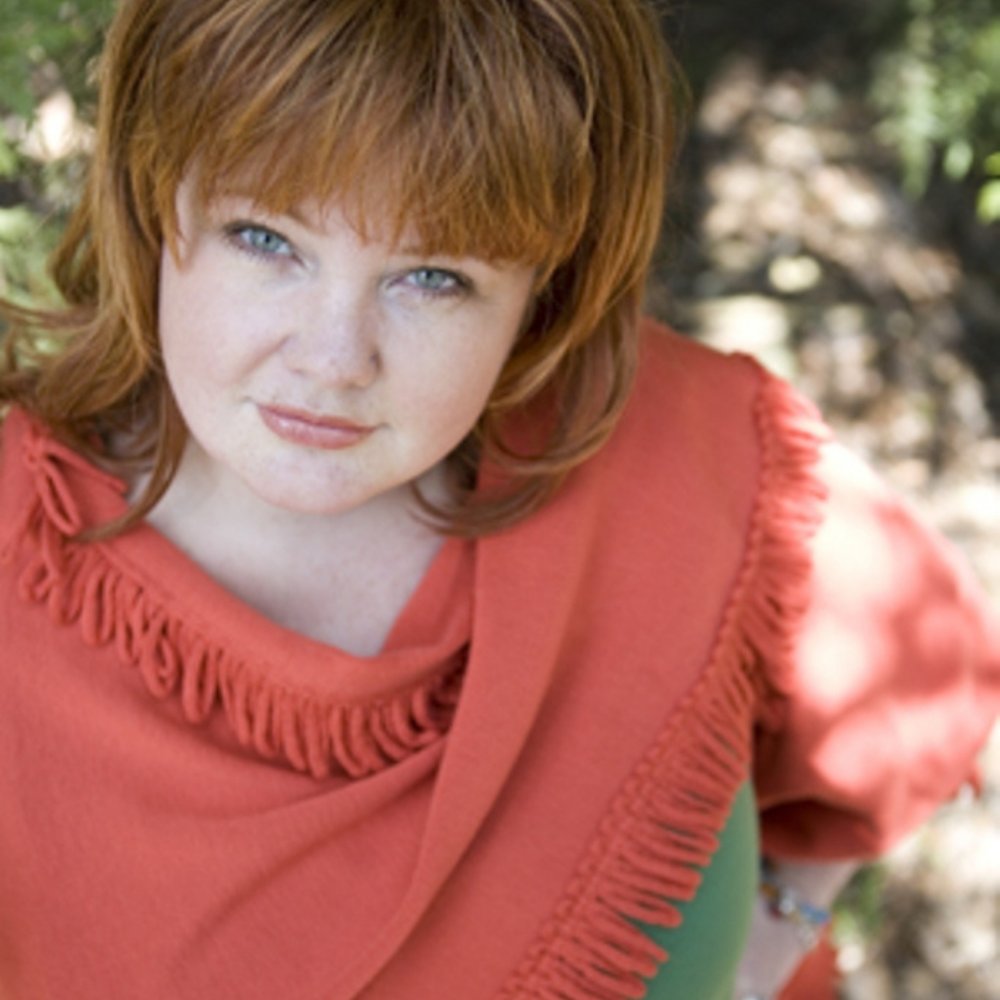 Renee Shupe in a coral shawl, looking up at the camera